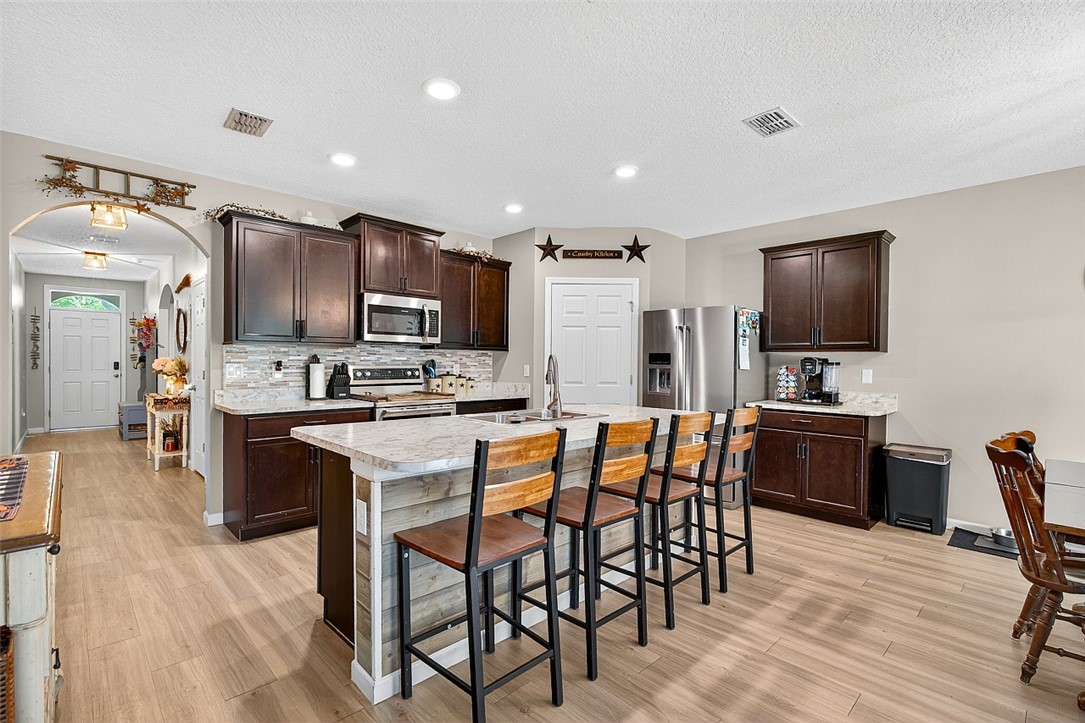 233 Periwinkle Drive Sebastian, FL 32958 - Photo 3 of 34 a kitchen with stainless steel appliances kitchen island granite countertop a sink a stove a dining table and chairs