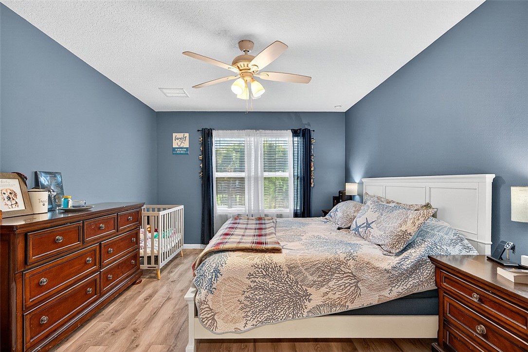 233 Periwinkle Drive Sebastian, FL 32958 - Photo 4 of 34 a bedroom with a bed and a chandelier