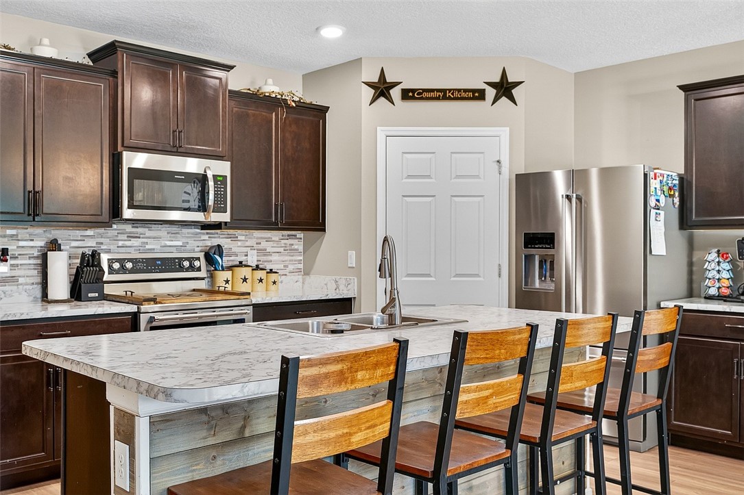 233 Periwinkle Drive Sebastian, FL 32958 - Photo 6 of 34 a kitchen with stainless steel appliances a stove microwave and refrigerator