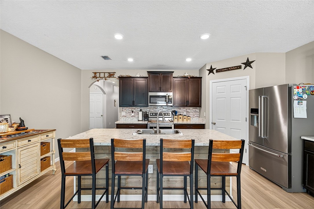 233 Periwinkle Drive Sebastian, FL 32958 - Photo 7 of 34 a kitchen with kitchen island a refrigerator a table and chairs