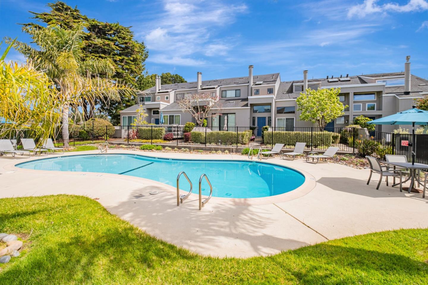 1067 Vía Tornasol Aptos, CA 95003 - Photo 34 of 38 a view of a swimming pool with a lawn chairs under an umbrella