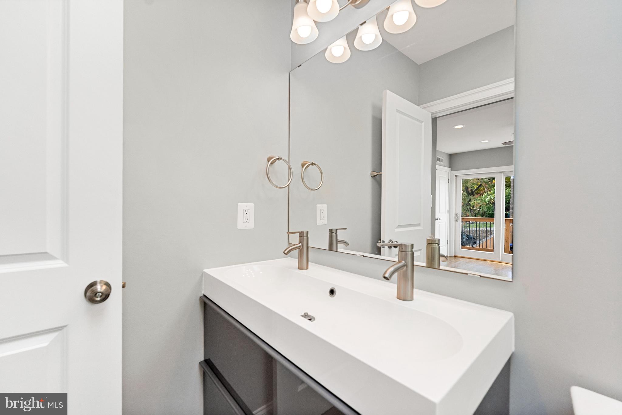 1423 Montello Avenue Northeast Washington, DC 20002 - Photo 19 of 30 a bathroom with a sink a mirror and a window
