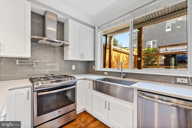a kitchen with stainless steel appliances granite countertop a sink stove and cabinets