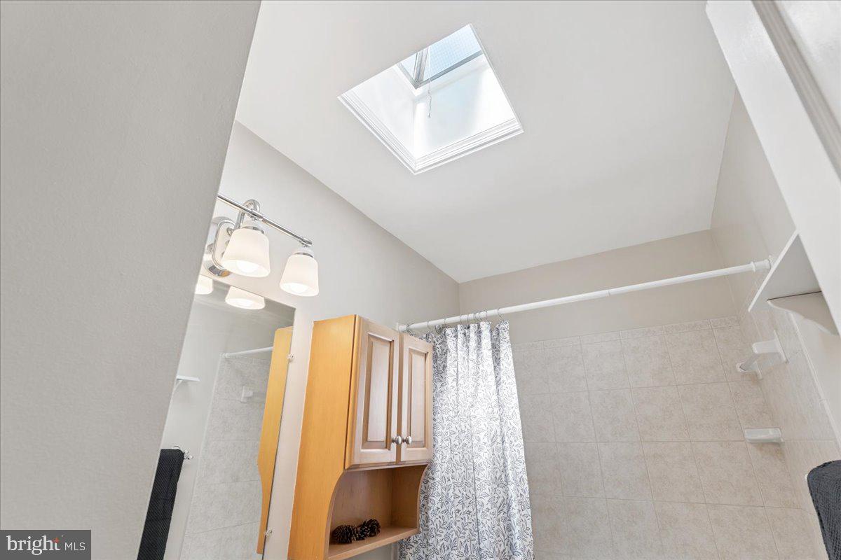 7024 Conley Street Baltimore, MD 21224 - Photo 13 of 20 a view of walk in closet with window and bathroom