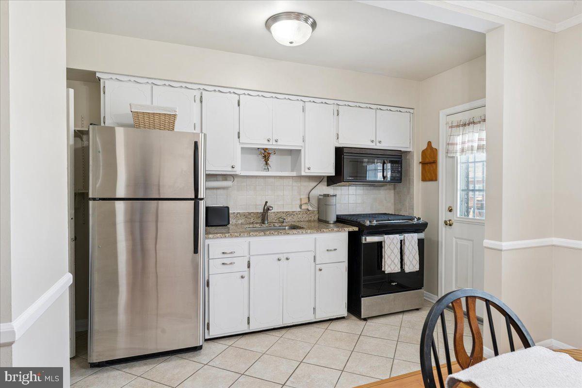 7024 Conley Street Baltimore, MD 21224 - Photo 9 of 20 a kitchen with stainless steel appliances granite countertop a refrigerator stove a sink and a microwave