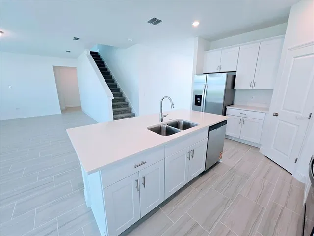 a kitchen with stainless steel appliances a refrigerator a sink a stove and cabinets