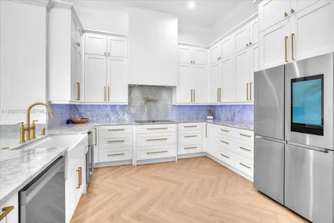 a kitchen with kitchen island stainless steel appliances a sink and white cabinets