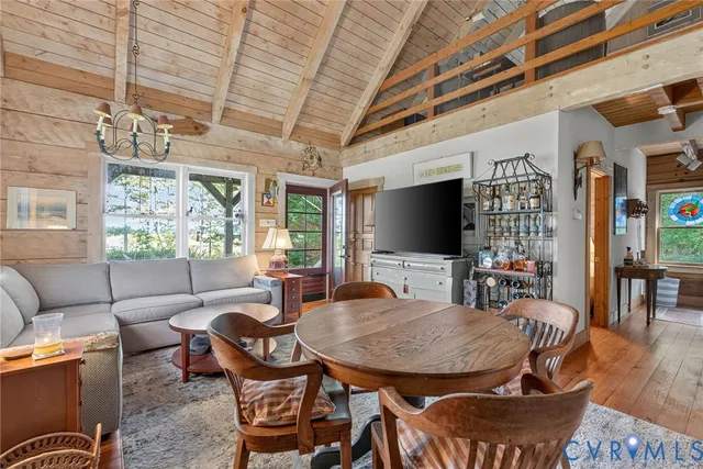 a living room with furniture a flat screen tv and a chandelier