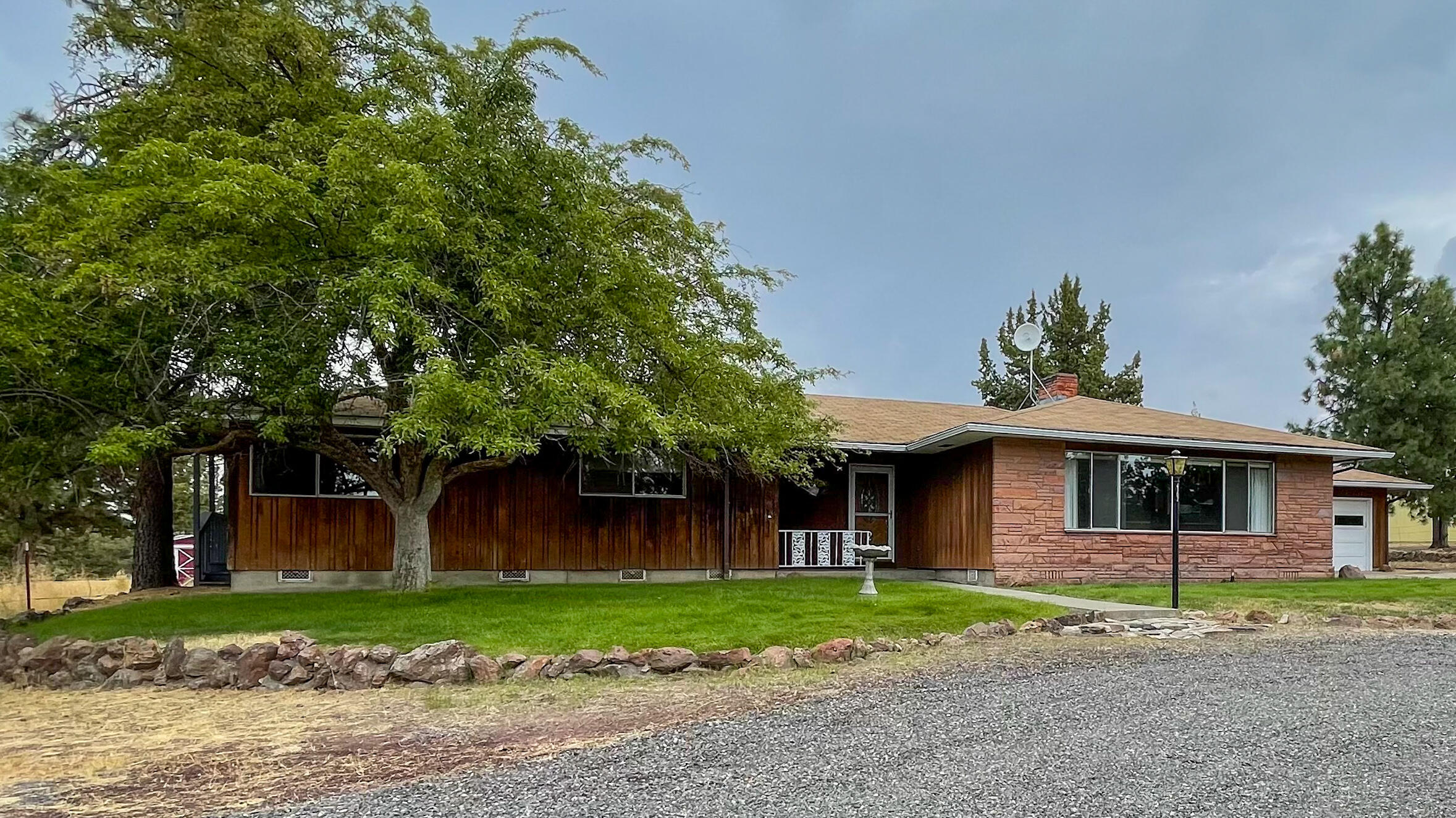 6302 Stillman Road Powell Butte, OR 97753 - Photo 1 of 39 a front view of a house with a garden