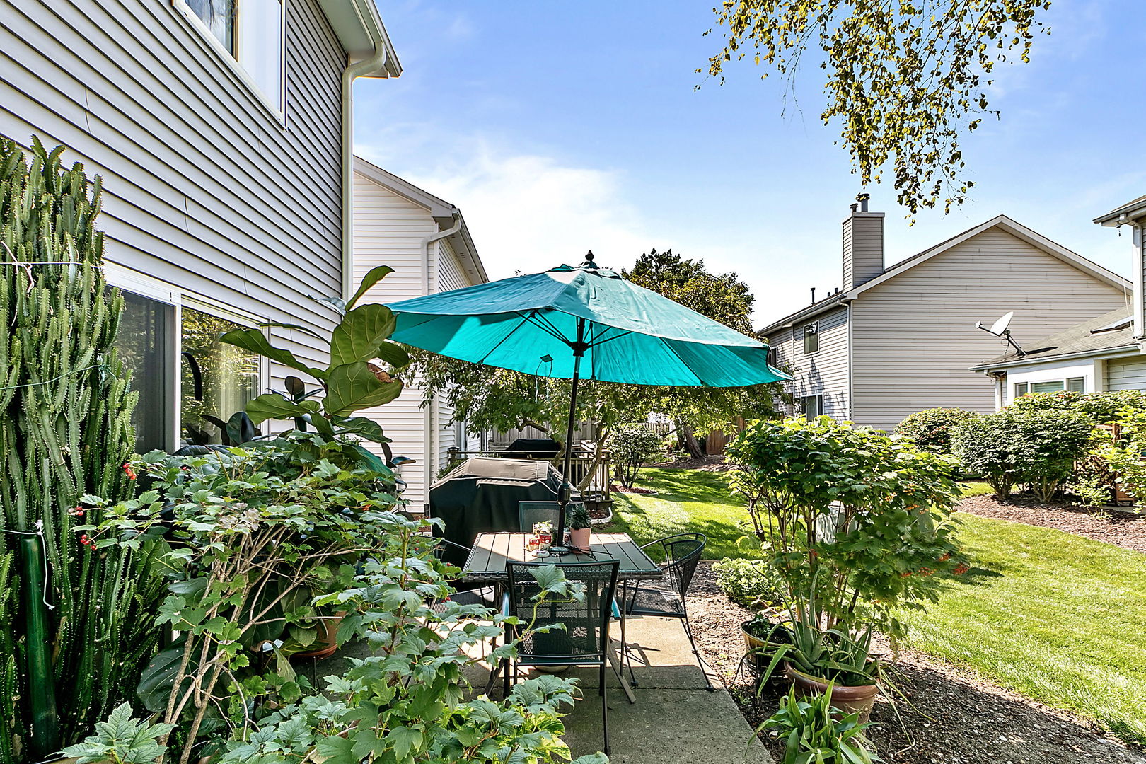116 Hampton Avenue Westmont, IL 60559 - Photo 15 of 19 a backyard of a house with table and chairs under an umbrella