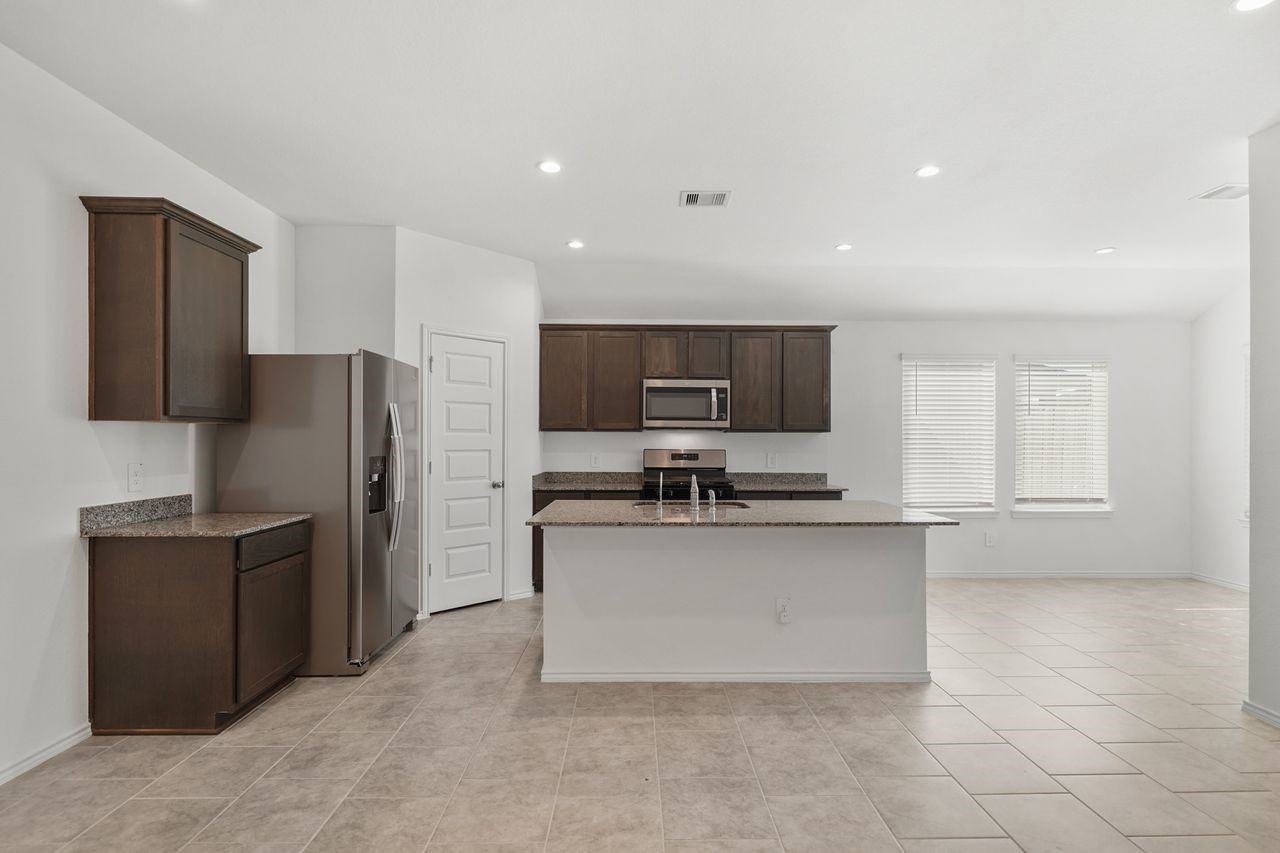 7502 Fierce Friesian Lane Rosharon, TX 77583 - Photo 6 of 21 a kitchen with stainless steel appliances a refrigerator and a stove top oven