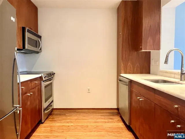 a kitchen with stainless steel appliances granite countertop a sink and a stove top oven
