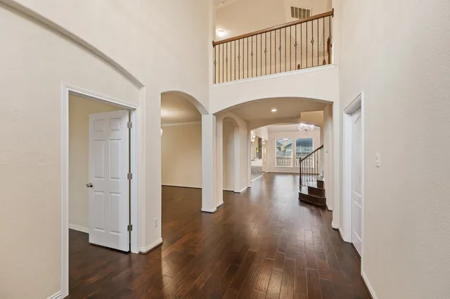 a view of a hallway with wooden floor and staircase