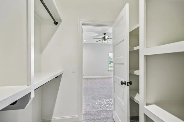 an empty room with a window and a fan