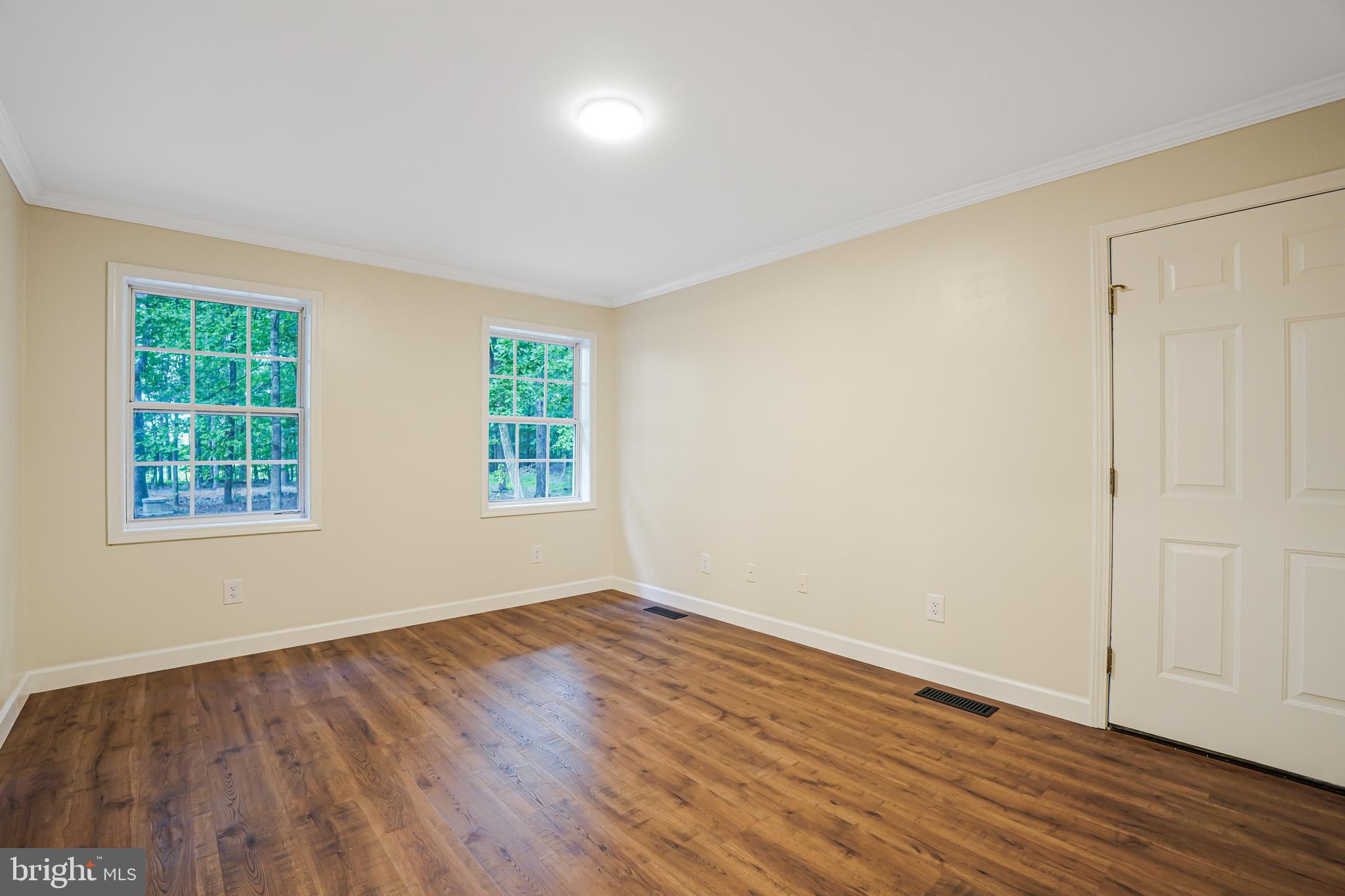 767 Loving Road Zion Crossroads, VA 22942 - Photo 22 of 33 an empty room with wooden floor and windows