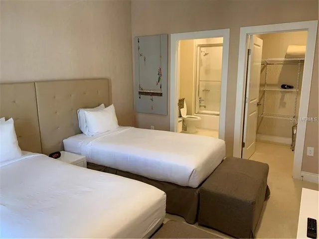 a bedroom with two beds and painting on the wall