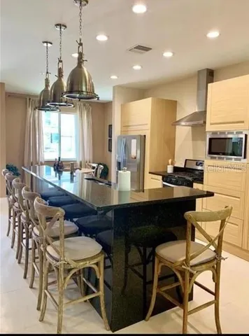 a kitchen with a dining table chairs sink and white cabinets
