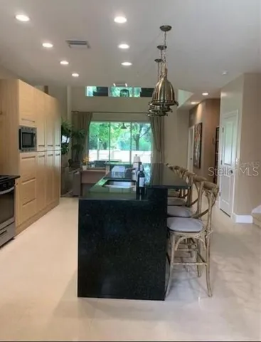 a room with dining table chairs wooden floor and a chandelier