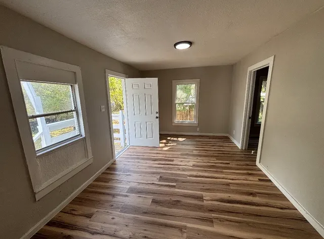 a view of a livingroom with wooden floor and window
