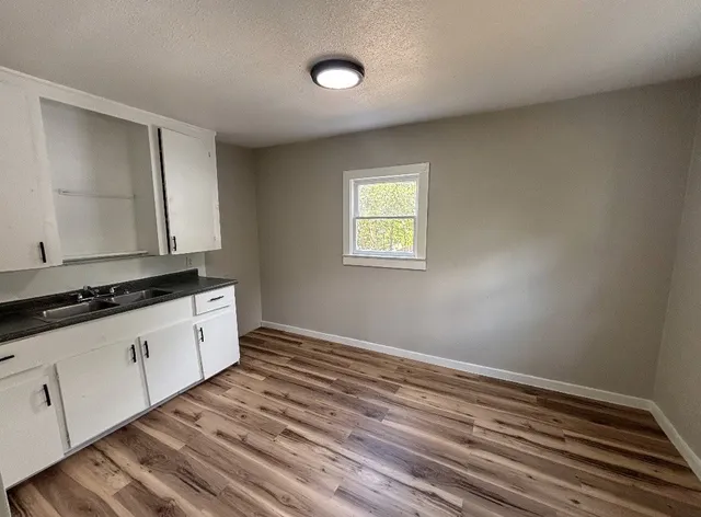 a room with a sink cabinets and wooden floor