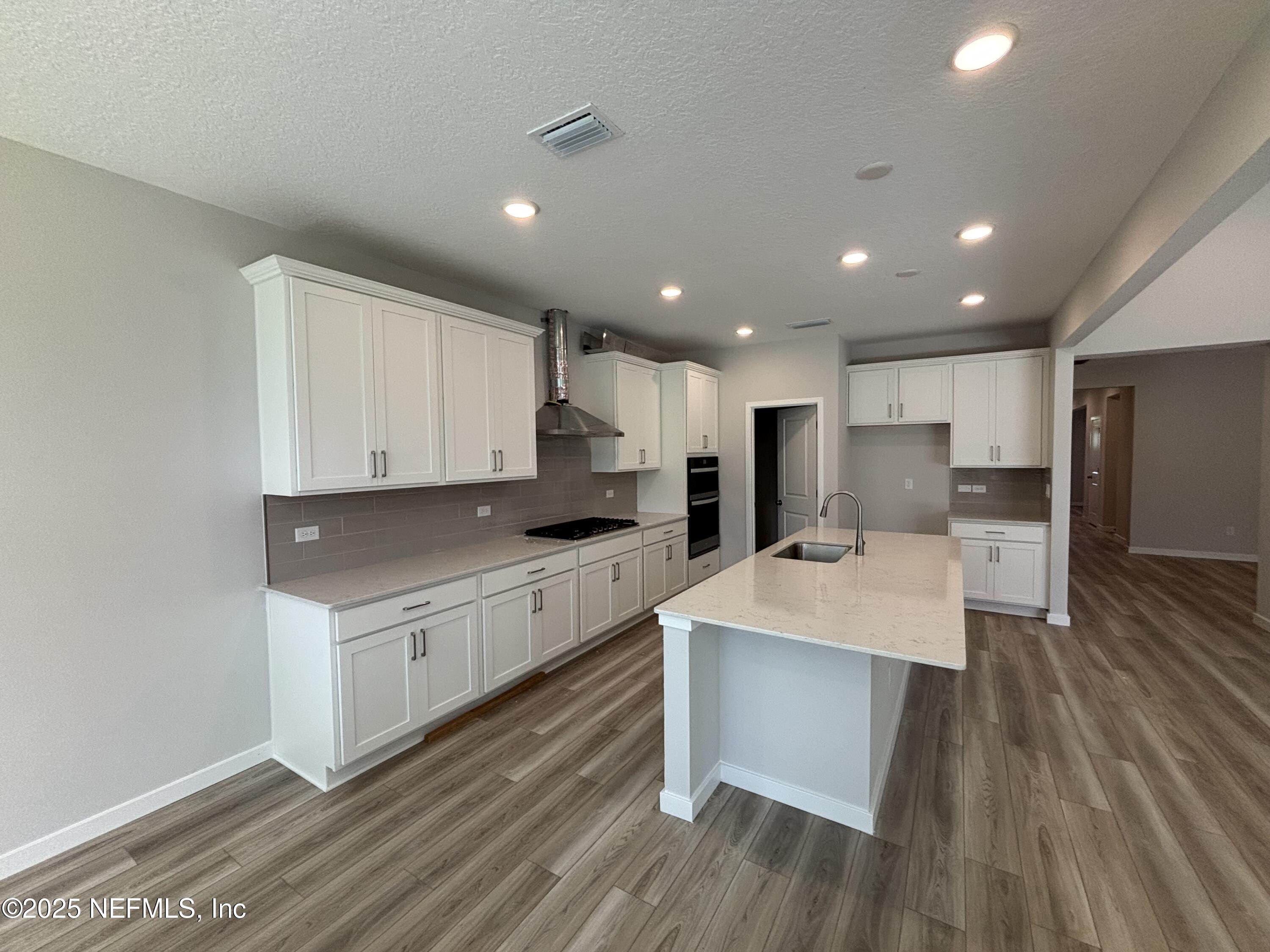 67 Pegasus Road Flagler Beach, FL 32136 - Photo 18 of 34 a large kitchen with stainless steel appliances kitchen island a large counter top and wooden floors