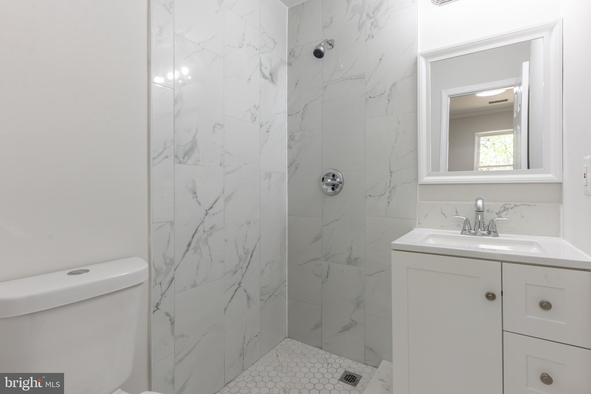 5506 Joplin Street Springfield, VA 22151 - Photo 14 of 32 a bathroom with a shower sink and mirror