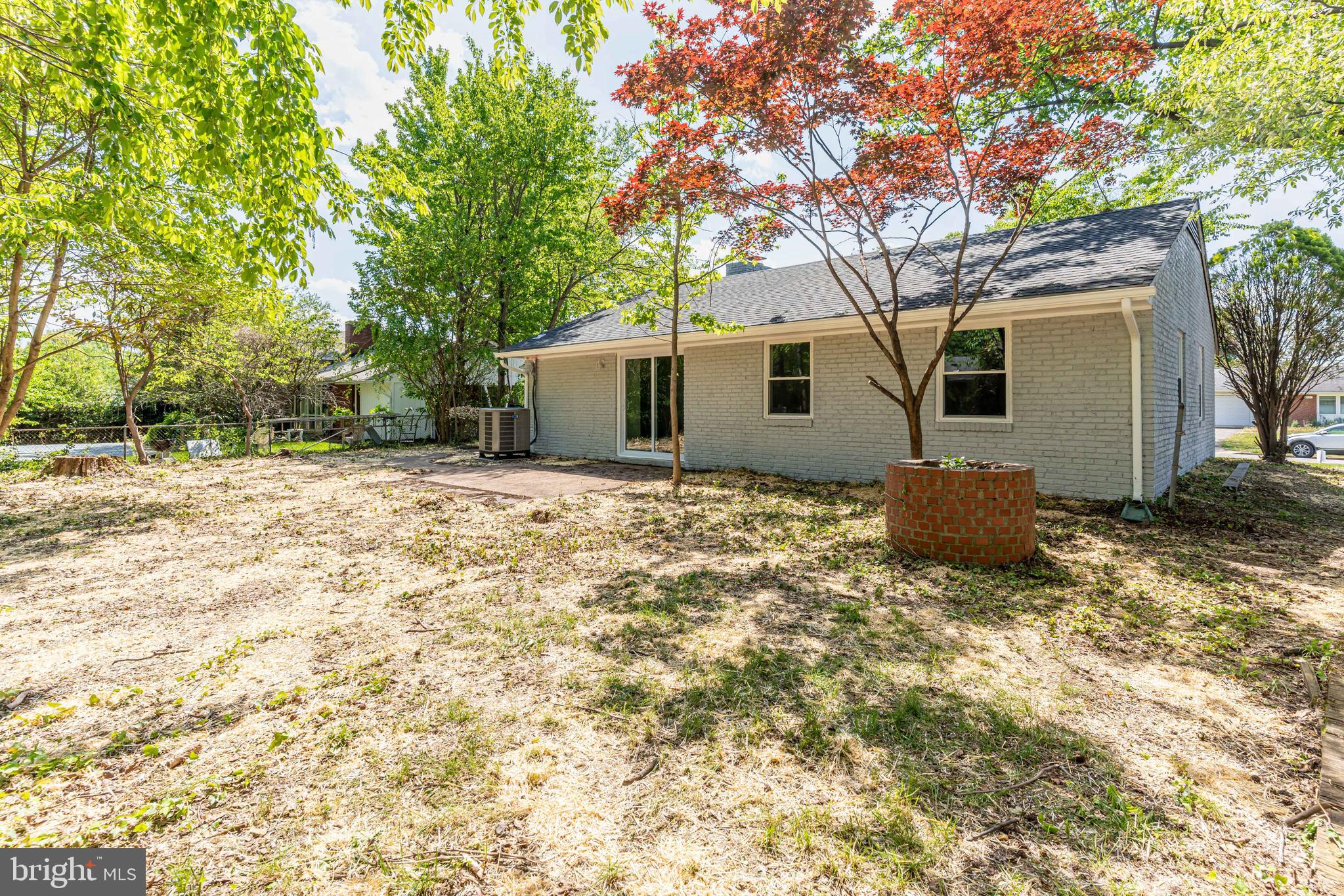 5506 Joplin Street Springfield, VA 22151 - Photo 30 of 32 a backyard of a house with large trees and brick walls