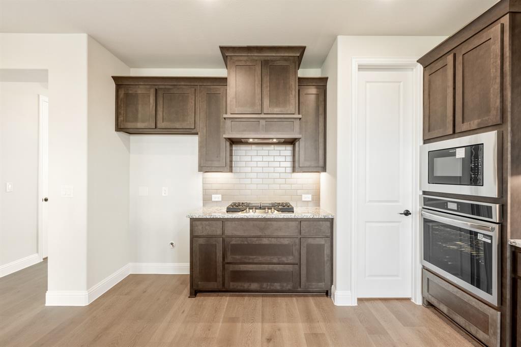14422 McClint Street Pilot Point, TX 76258 - Photo 11 of 40 a kitchen with granite countertop cabinets and steel stainless steel appliances