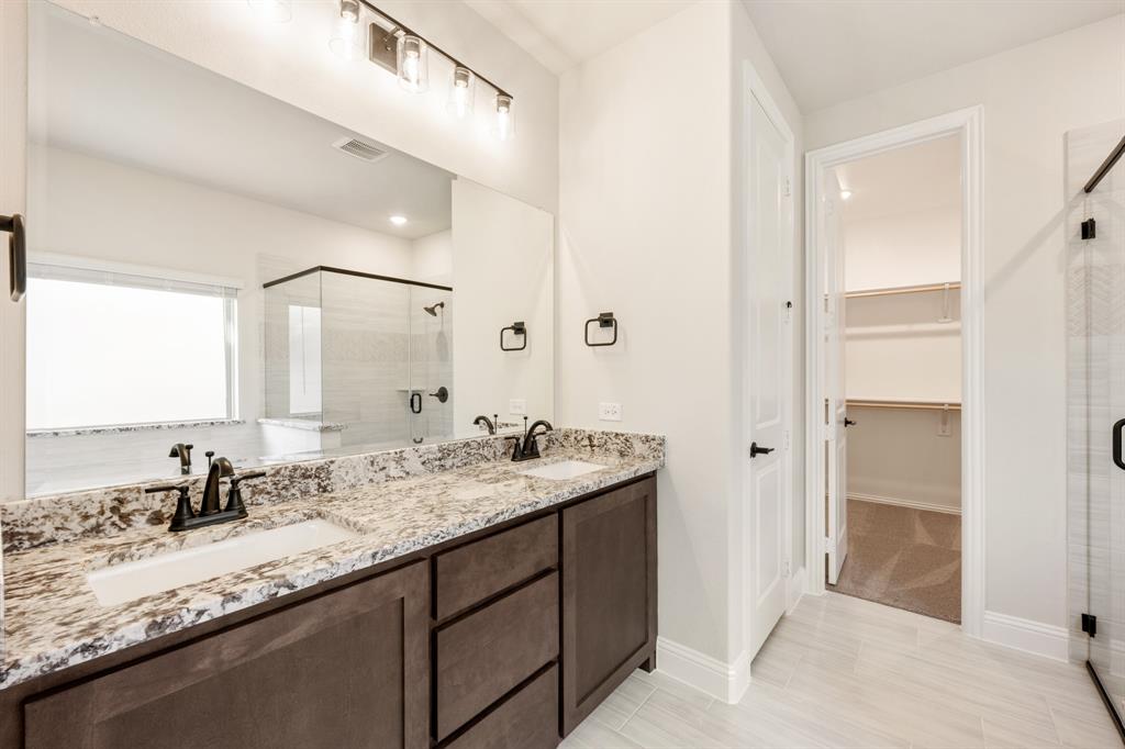 14422 McClint Street Pilot Point, TX 76258 - Photo 22 of 40 a bathroom with a granite countertop sink and a mirror
