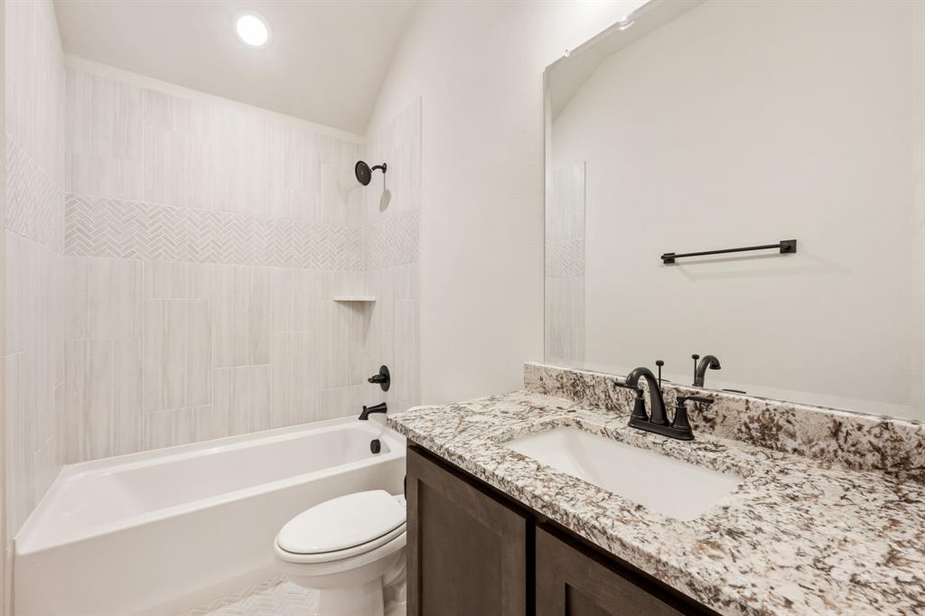 14422 McClint Street Pilot Point, TX 76258 - Photo 35 of 40 a bathroom with a granite countertop sink toilet and shower