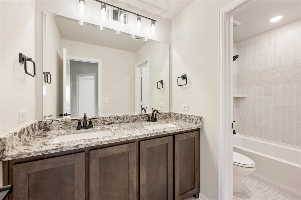 14422 McClint Street Pilot Point, TX 76258 - Photo 36 of 40 a bathroom with a granite countertop sink toilet and shower