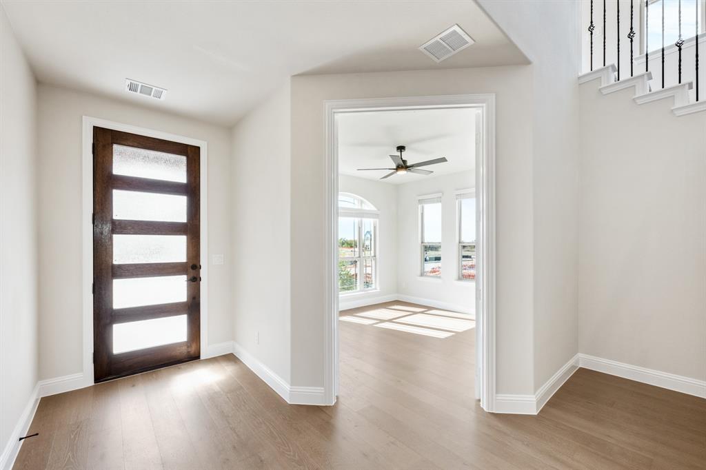 14422 McClint Street Pilot Point, TX 76258 - Photo 4 of 40 an empty room with wooden floor cabinet and windows