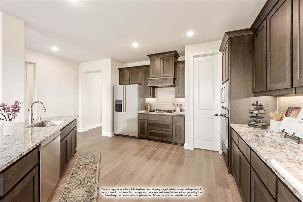 14422 McClint Street Pilot Point, TX 76258 - Photo 10 of 40 a kitchen with stainless steel appliances kitchen island granite countertop a sink stove and refrigerator