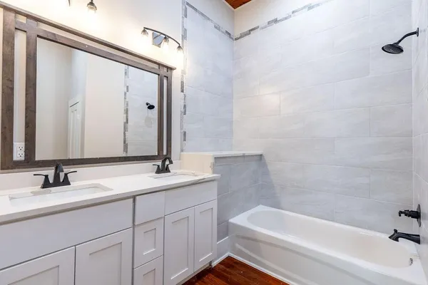 a bathroom with a tub sink and mirror