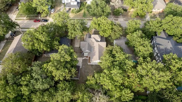an aerial view of residential house with outdoor space and trees all around