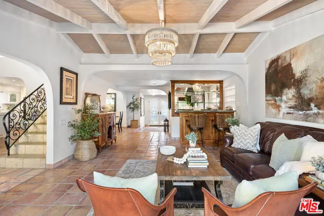 a living room with furniture a chandelier and a large window