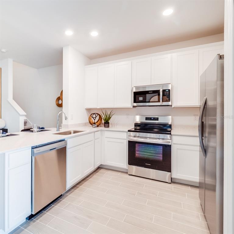 3639 Southeast 37th Ave Road Ocala, FL 34480 - Photo 47 of 61 a kitchen with granite countertop a refrigerator stove and microwave