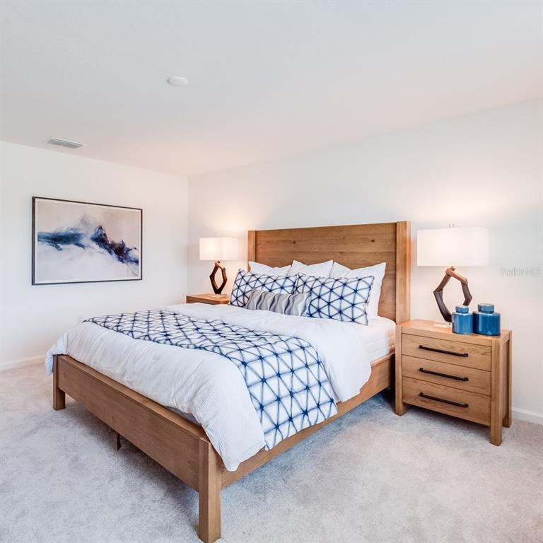 3639 Southeast 37th Ave Road Ocala, FL 34480 - Photo 57 of 61 a spacious bedroom with a bed and lamp