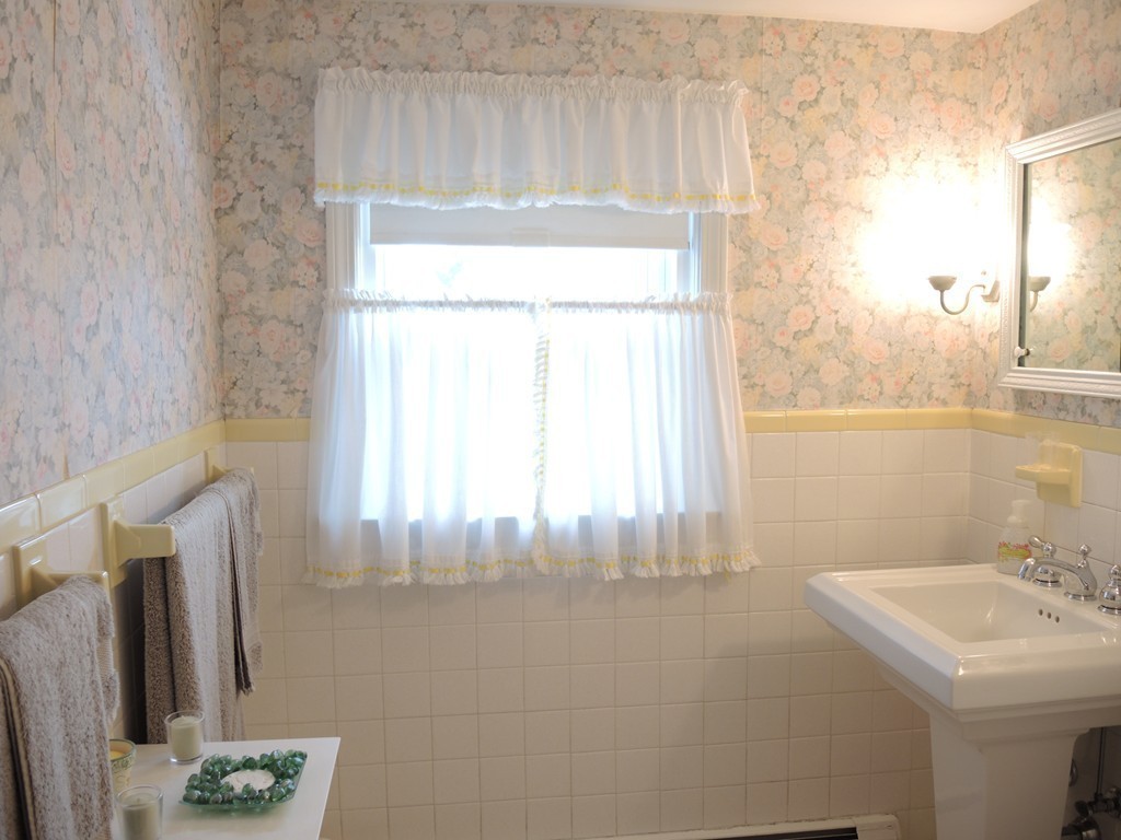 21 Lawton Road Needham, MA 02492 - Photo 19 of 28 a bathroom with a sink a mirror and a window