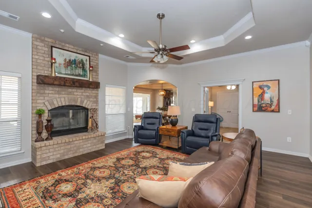 a living room with furniture a fireplace and a chandelier