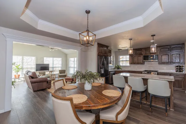 a view of a dining room with furniture wooden floor and chandelier
