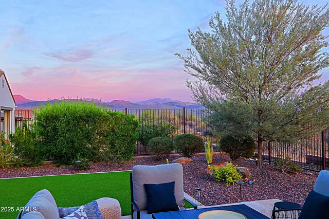 a view of a chairs and table in the backyard