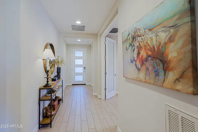 a view of a hallway with wooden floor and stairs
