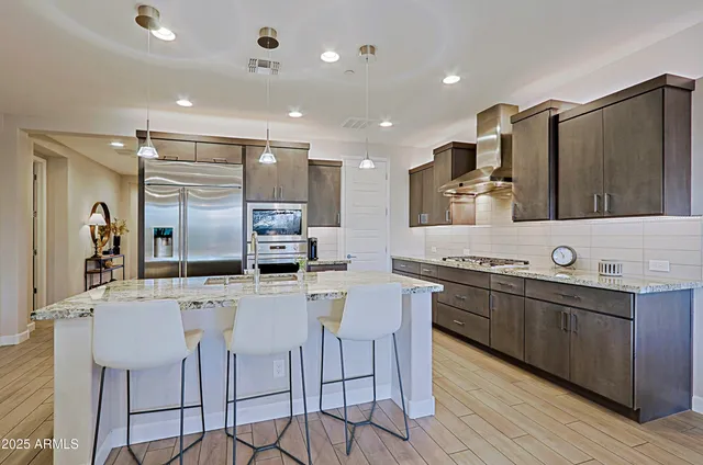 a kitchen with stainless steel appliances kitchen island granite countertop a sink and cabinets