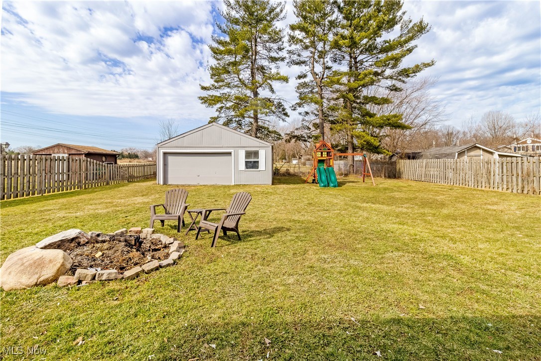 5900 Lear Nagle Road North Ridgeville, OH 44039 - Photo 33 of 35 View of yard with an outbuilding, an outdoor fire pit, a playground, and a fenced backyard