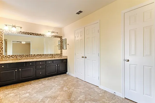 a spacious bathroom with a granite countertop sink mirror and a