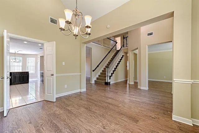 a view of a hallway with wooden floor and staircase