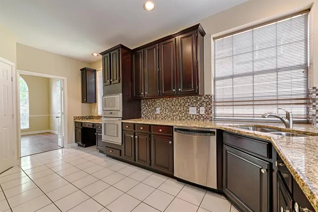 a kitchen with stainless steel appliances granite countertop a stove sink and cabinets