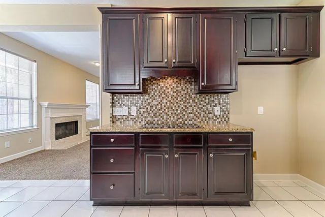 a view of kitchen with granite countertop wooden cabinets and a stove top oven