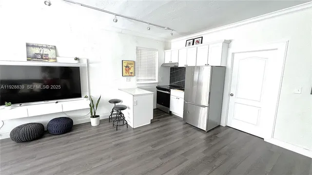 a kitchen with stainless steel appliances a refrigerator stove and wooden floor